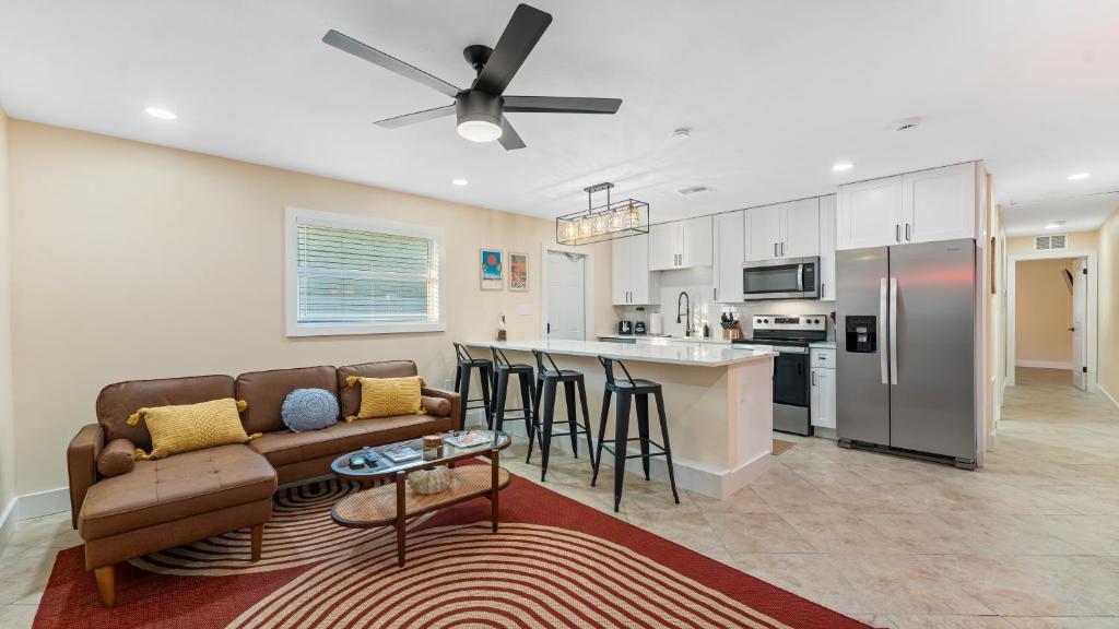 a living room with a couch and a kitchen at The Shark Tank Cocoa Beach - Retro Florida, Downtown, 5-Min Walk to Beach, Shops & Bars in Cocoa Beach