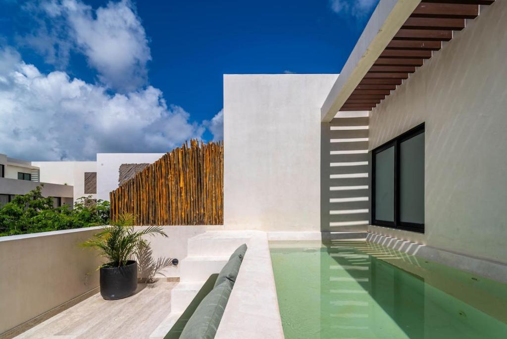 a house with a swimming pool next to a building at 3BR Penthouse with Private Plunge Pool in Tulum