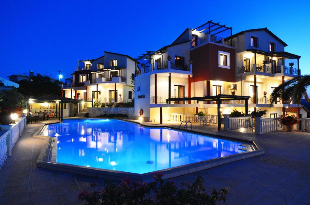 a swimming pool in front of a house at night at Antilia Apartments in Tavronitis