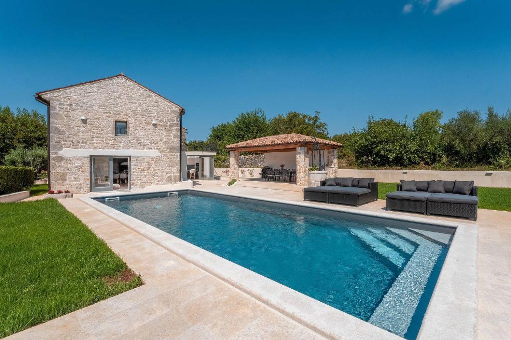 a swimming pool in a yard with a stone house at Beeindruckende Steinfinca mit privatem Salzwasserpool, Panoramablick aufs Meer, Grill in Orbani
