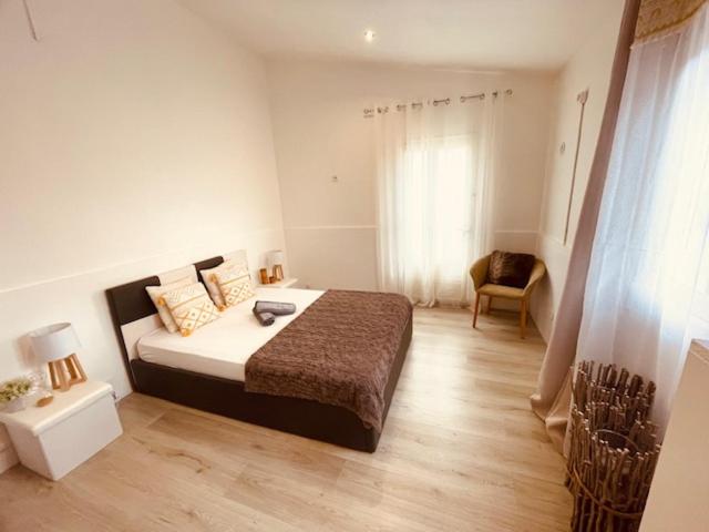 a bedroom with a large bed and a chair at Lily House in Sainte-Marie