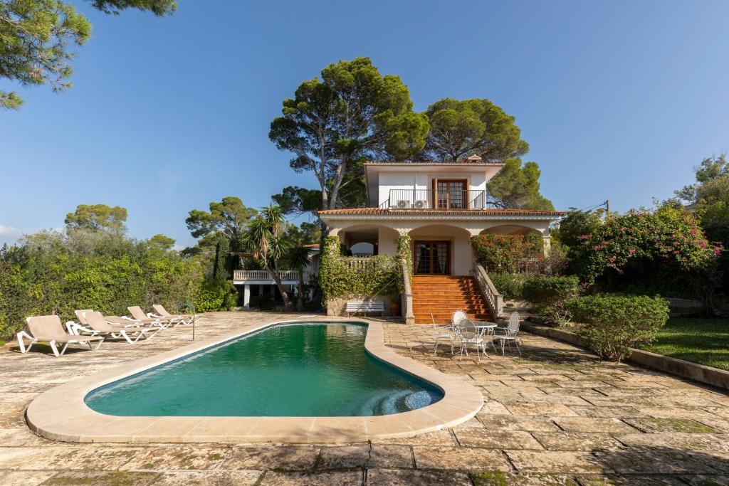 a villa with a swimming pool in front of a house at Villa Rosa, espaciosa casa con piscina in Marratxí 