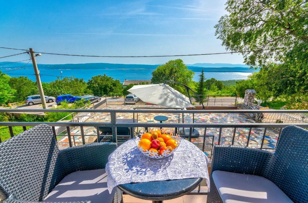 德拉马利Beeindruckendes Apartment mit Whirlpool, Lounge-Liegen, Meerblick, Grill的阳台上的一张桌子上放着一碗水果