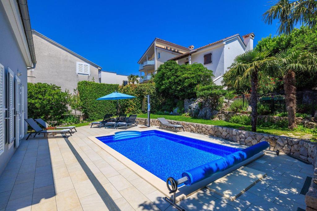 ein Swimmingpool im Hinterhof eines Hauses in der Unterkunft Strandnahe Villa mit Meerblick, 2 Bikes, beheiztem Privatpool - nur 300 Meter zum Strand in Dramalj
