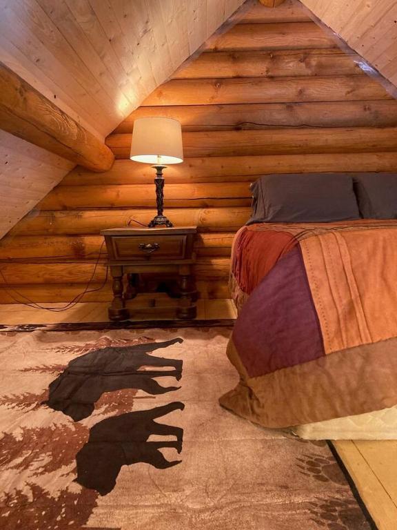 Postel nebo postele na pokoji v ubytování Log lofted rustic cabin in woods
