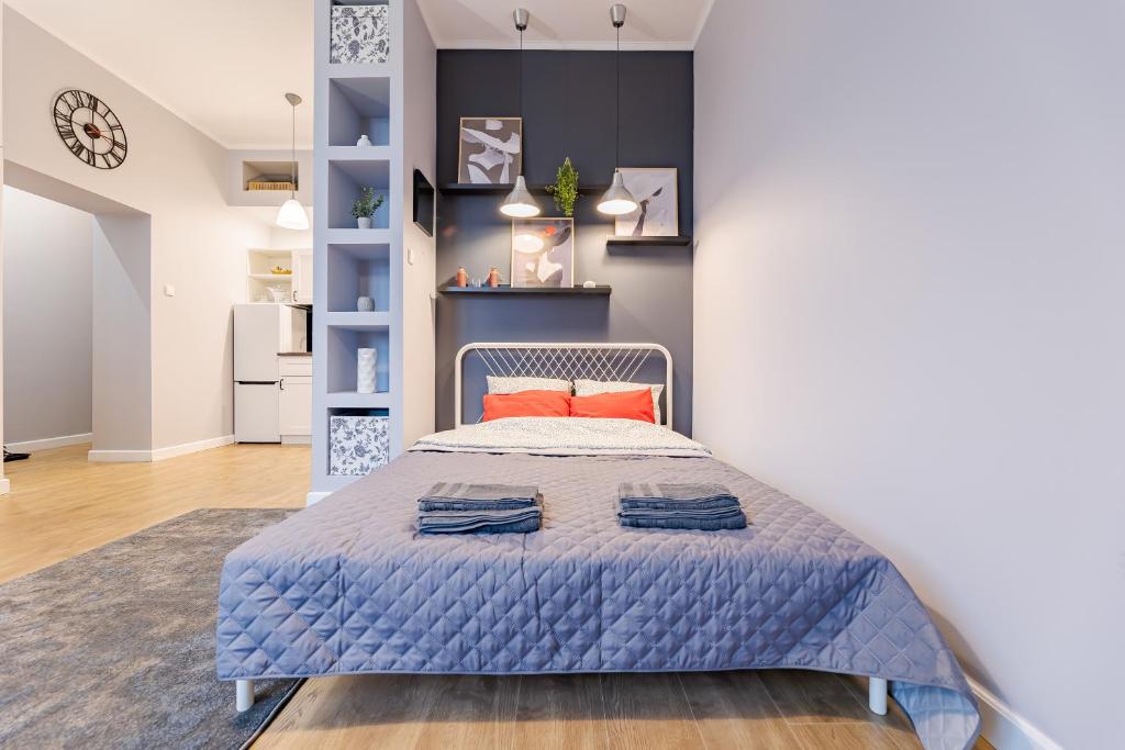 a bedroom with a bed with blue sheets and orange pillows at Time Apartment,Parking,Wi-Fi in Łódź