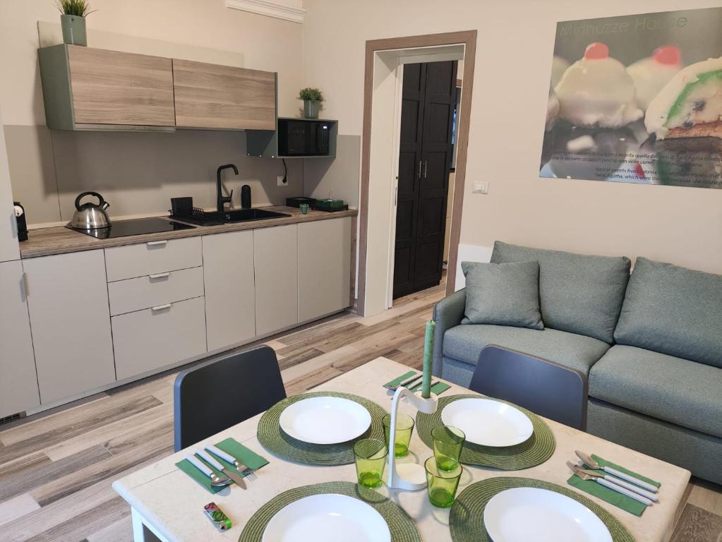una sala de estar con una mesa y un sofá en Minnuzze House, en Catania