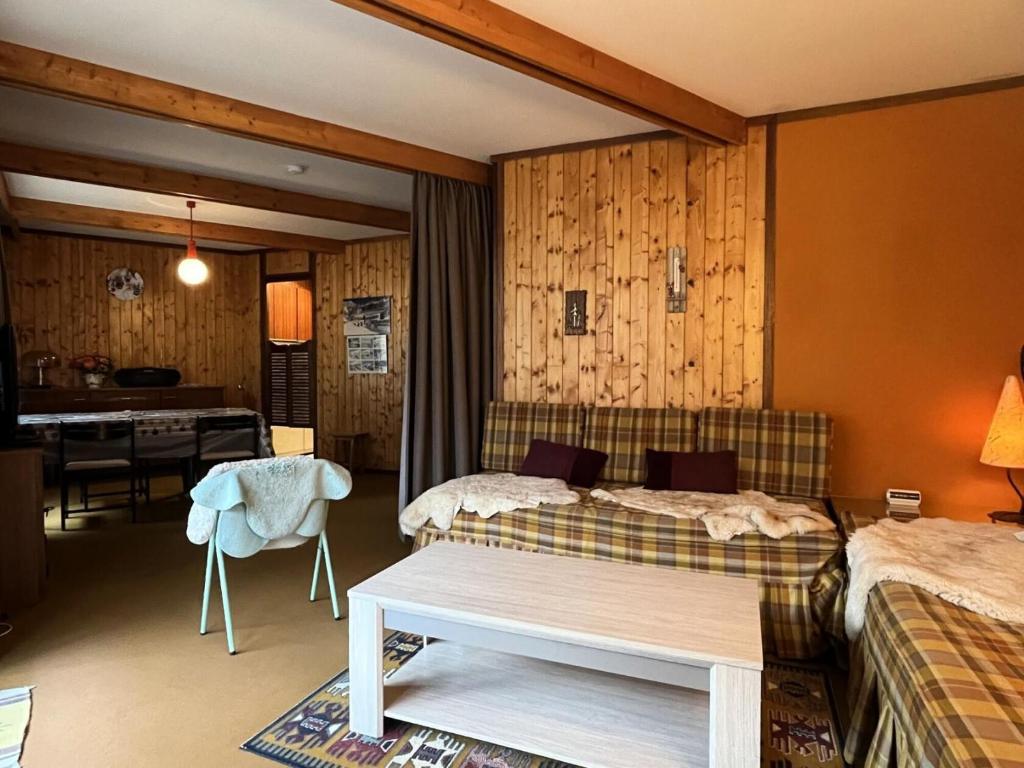 a bedroom with two beds and a table in it at Résidence Bero Bisto - maeva Home - Studio 4 personnes - Confort MAE-1951 in La Mongie