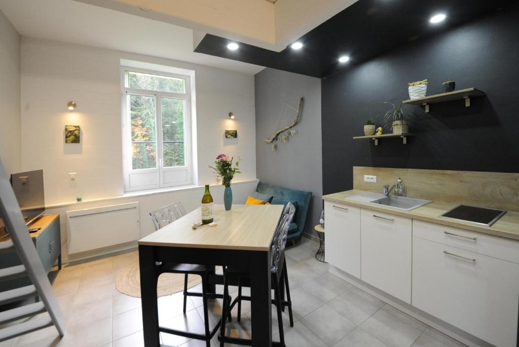 - une cuisine avec une table et un évier dans l'établissement L' Empesson, à Clairvaux-les-Lacs