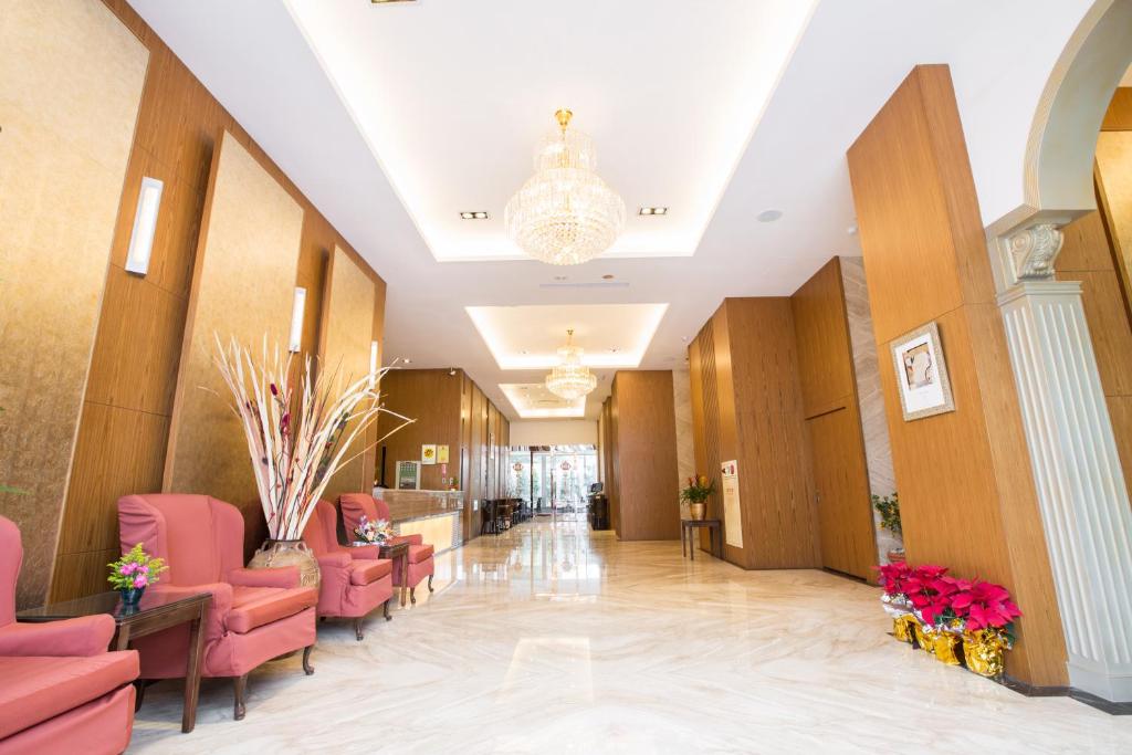 a hospital hallway with pink chairs and a chandelier at York Hotel in Taipei