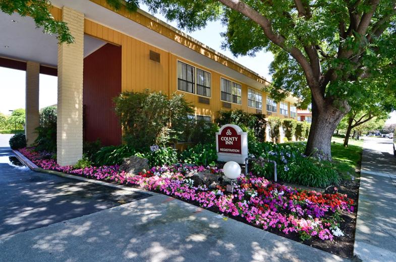 ein Hotel mit Blumen vor einem Gebäude in der Unterkunft County Inn in Mountain View