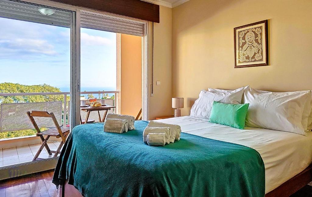 una camera da letto con un letto e una grande finestra di Caniço Zentrum Wohnung a Caniço