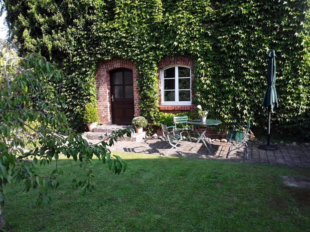 a house with a window and a table in a yard at Geräumige Ferienwohnung In Einem Umgebauten Stallgebäude in Ferchesar
