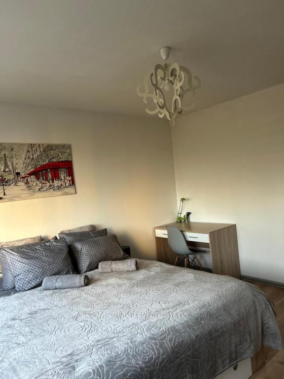 sypialnia z łóżkiem, biurkiem i żyrandolem w obiekcie Apartament Wieluńska w Warszawie