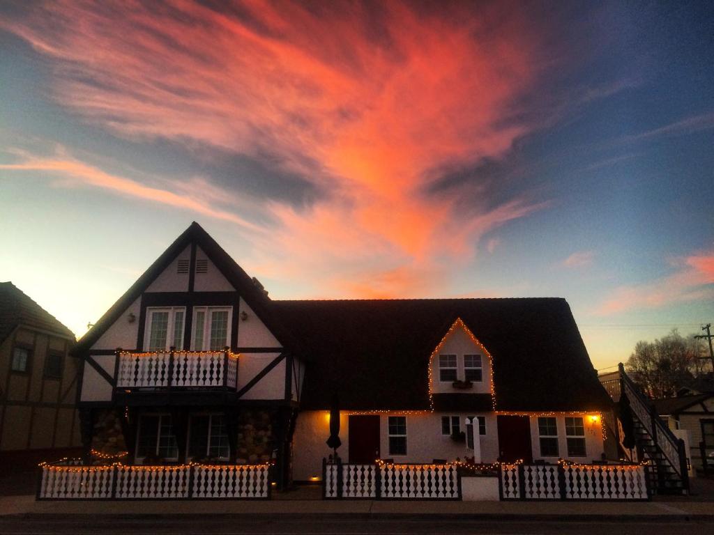 a house with a cloudy sky at sunset at New Haven Inn in Solvang