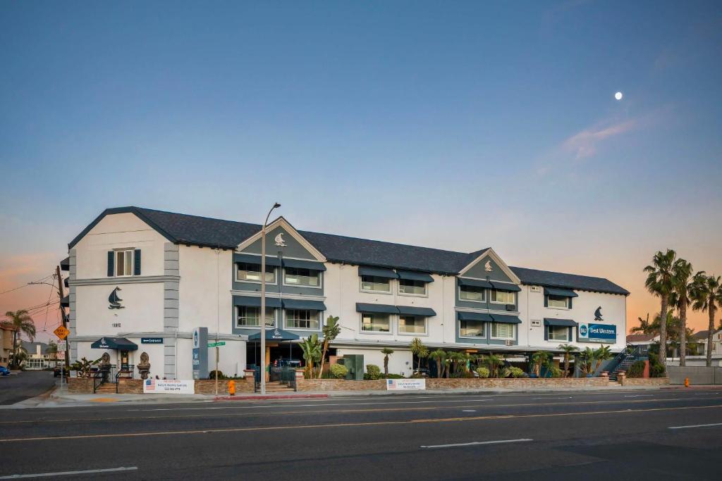 a large white building on the side of a street at Best Western Harbour Inn & Suites Huntington - Sunset Beach in Huntington Beach