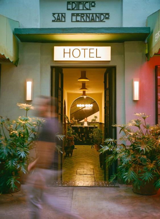 a man is walking into a hotel at Hotel San Fernando in Mexico City