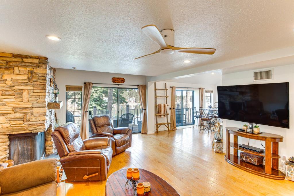 a living room with leather furniture and a large tv at Central Condo with Water Views in Lake Arrowhead! in Lake Arrowhead