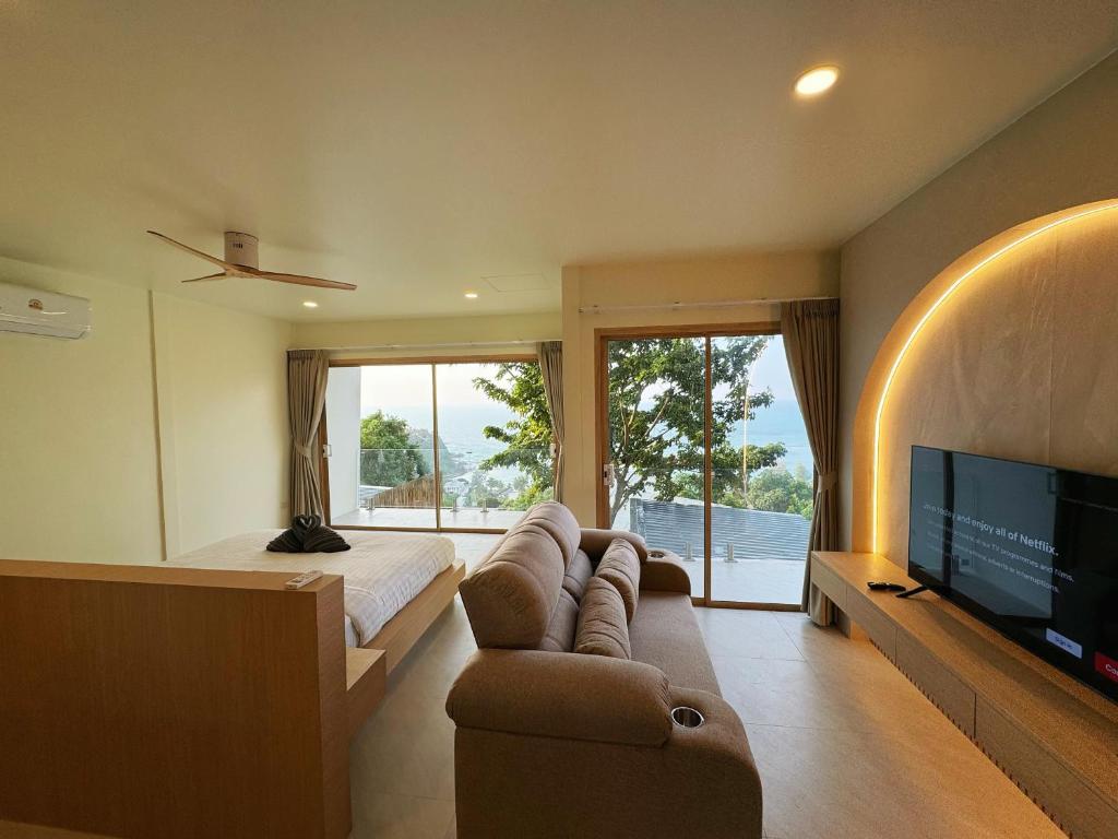 ein Wohnzimmer mit einem Sofa, einem Bett und einem TV in der Unterkunft High Life Villas in Salad Beach