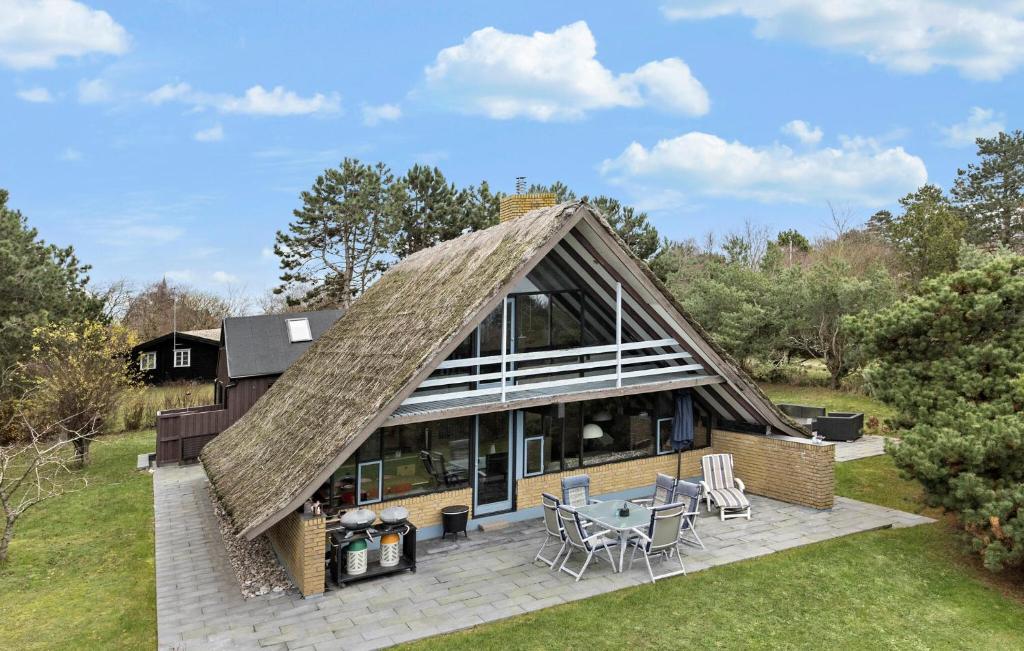 a house with a thatched roof on a patio at 3 Bedroom Nice Home In Humble in Humble