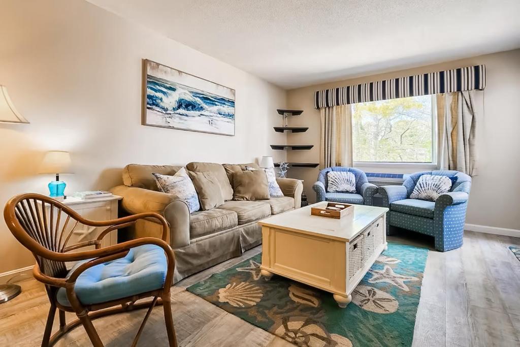 Una sala de estar con un sofá y sillas y una mesa. en The Condo at Ocean Edge, en Brewster