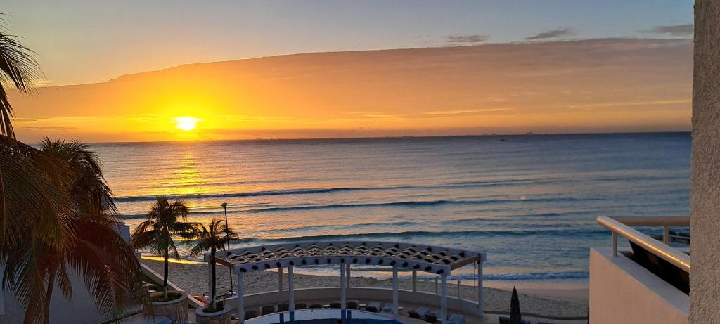 a sunset on the beach with the sun setting at SUNSET FISHERMEN BEACH & SPA RESORT-Optional All Inclusive- 3 UNITS CHOICE-ROOM - 344A Ocean view with terrace- ROOM 344B No terrace, View from window to park - STUDIO 344C Ocean View Studio for 2- Playacar, Phase 1 in Playa del Carmen