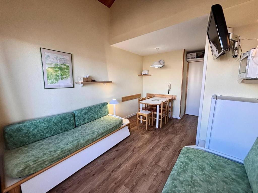 un salon avec un canapé vert et une table dans l'établissement Résidence Le Sextant - SEXTANT 405 MAE-0551, à La Plagne Tarentaise