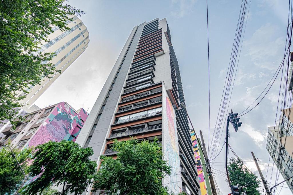 a tall building in the middle of a city at Piscina no Rooftop! Studio a 3min do Metrô República in São Paulo