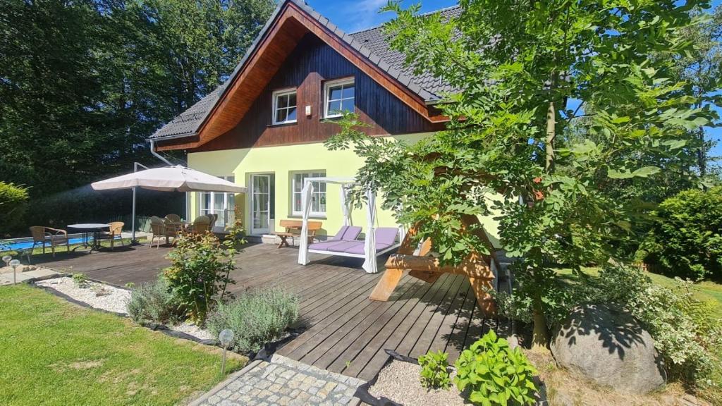dom z drewnianym tarasem i parasolem w obiekcie Dom Pod Sosną w mieście Karpacz