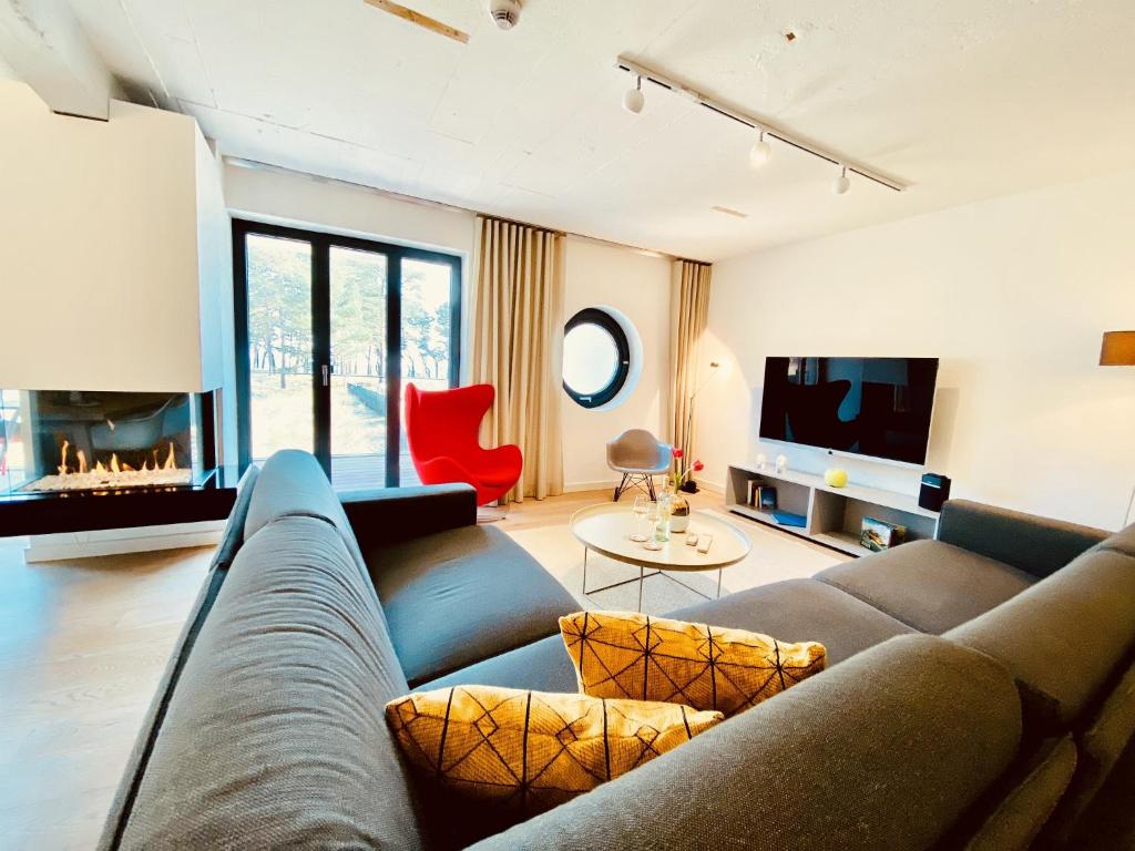 Ferienwohnung Proraloft 6 im Haus Prora Düne 7 في بينز: غرفة معيشة مع أريكة ومدفأة