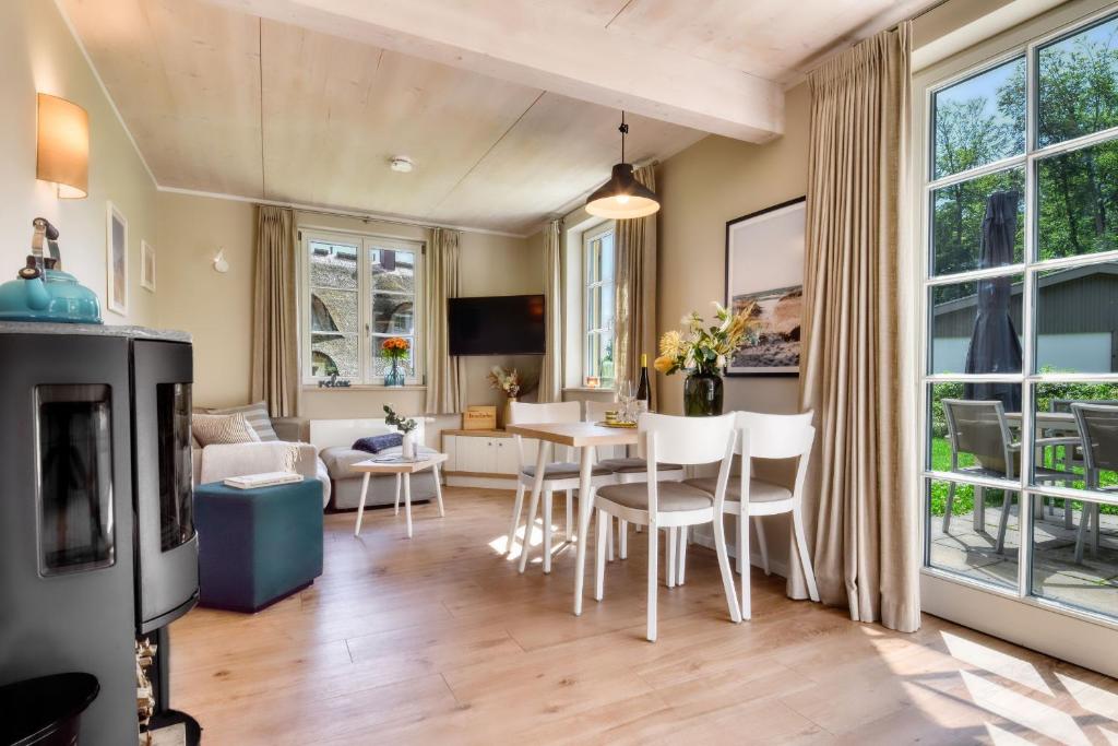 una sala de estar con una mesa y sillas en Ferienhaus Inselliebe 02 Feriendorf Klein Stresow Rügen by ruyastay, en Putbus