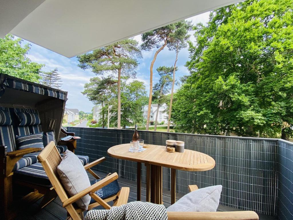a patio with a table and chairs on a balcony at Ferienwohnung Strandkorb & Mee h r Parkvillen Carlota und Candela Baabe in Baabe