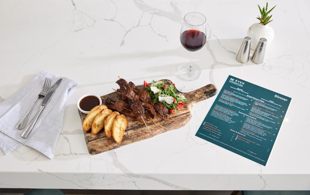 a plate of food on a table with a wine glass at EVEN Hotel Portland - Beaverton by IHG in Portland