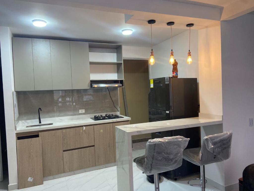 Una cocina con encimera, fregadero y frigorífico. en Apartamento Nuevo con Piscina Bien Ubicado, en Villavicencio