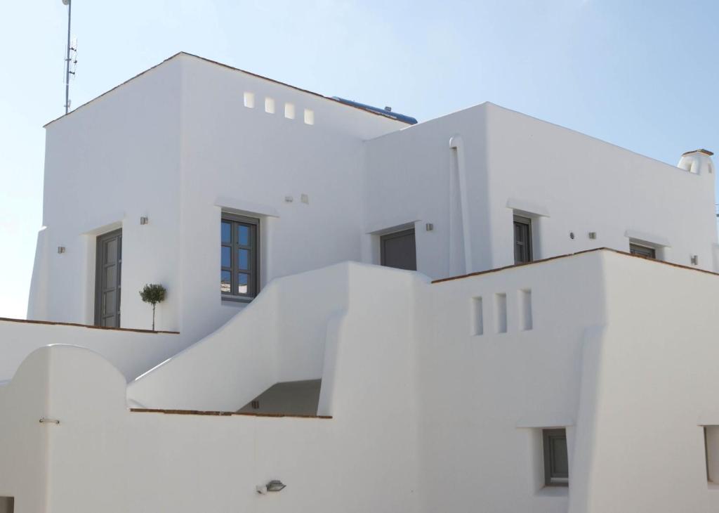 a white building with a slide on it at Enosis Apartments - Alia Beach House in Agios Prokopios