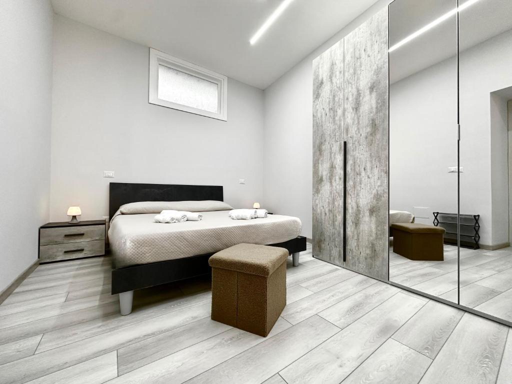 a white bedroom with a bed and a mirror at Il Belvedere dei Bizantini Apartaments in Melfi