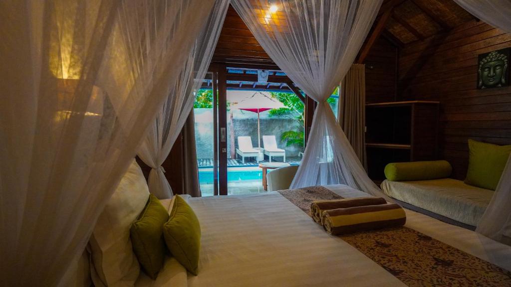 a bedroom with a bed with a mosquito net at Darsan Lembongan Boutique Cottage in Nusa Lembongan