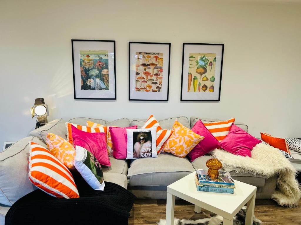 a living room with a couch with colorful pillows at Hertford farm Woodland cabin pet friendly firepit bbq in Hertford