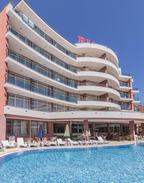 a hotel with a swimming pool in front of a building at Hotel RIAGOR - ALL INCLUSIVE in Sunny Beach