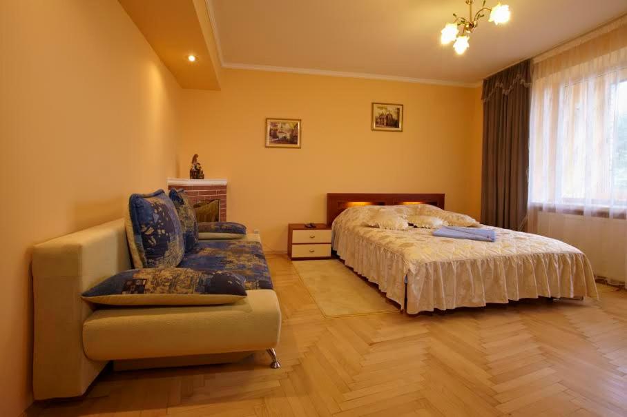 1 dormitorio con 1 cama, 1 sofá y 1 silla en Apartment Oksi en Leópolis