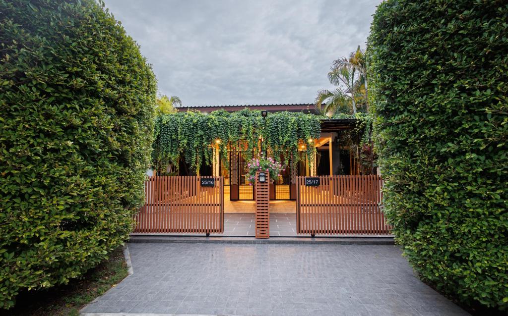 an open gate to a house with plants at T House in Bang Tao Beach
