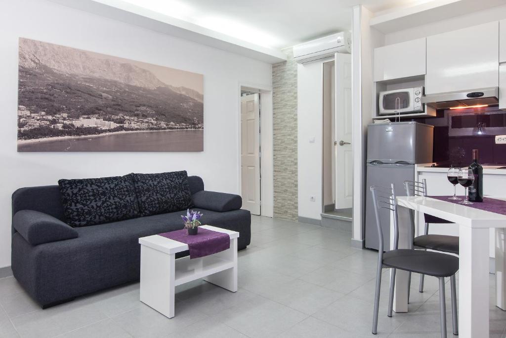 uma sala de estar com um sofá e uma cozinha em Apartments Smiljka em Tučepi