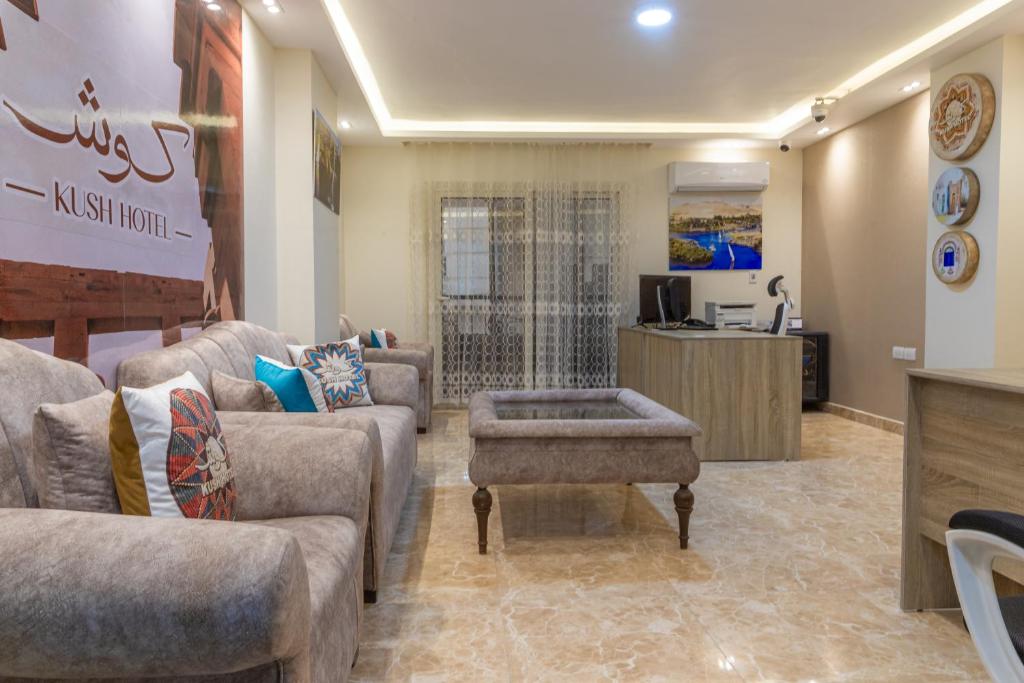 Kush Hotel, Grand Museum & Pyramids View في القاهرة: غرفة معيشة مع كنب وطاولة قهوة
