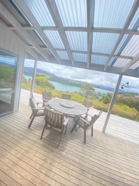a patio with a table and chairs on a deck at Mangonui Ridge Retreat in Mangonui