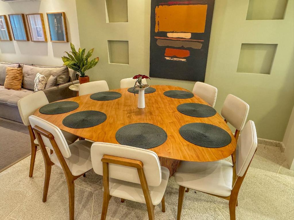 ein Esstisch und Stühle in einem Wohnzimmer in der Unterkunft Casa Bela - Centro in Águas de Lindóia