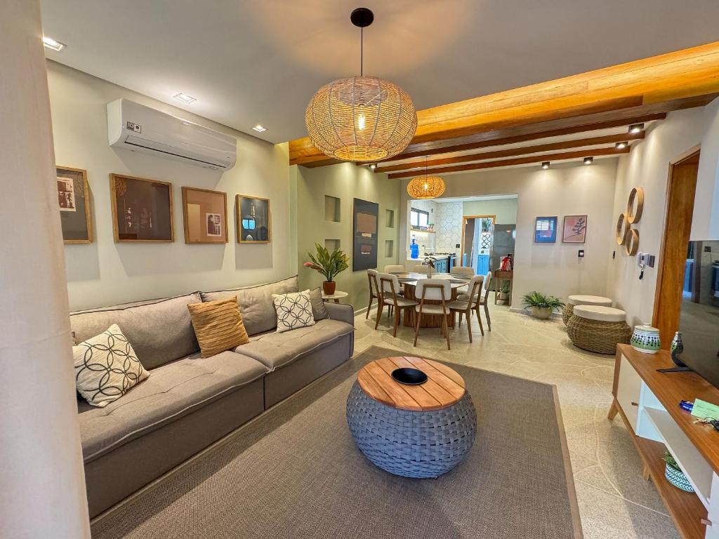 ein Wohnzimmer mit Sofa und Tisch in der Unterkunft Casa Bela - Centro - Ar condicionado Garagem Wi-fi in Águas de Lindóia