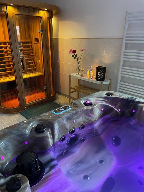 Cette chambre comprend un grand lit et une baignoire. dans l'établissement Jacuzzi & Sauna privatifs - Vue mer, à Blainville-sur-Mer