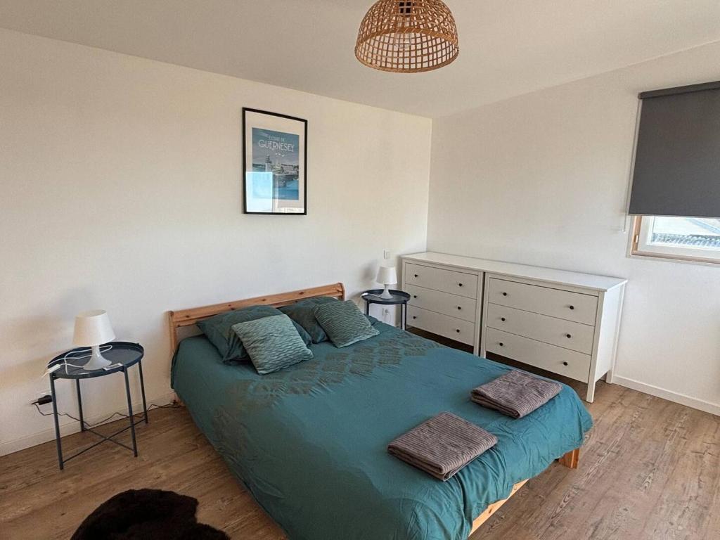 a bedroom with a blue bed with two pillows at Jacuzzi & Sauna privatifs - Vue mer in Blainville-sur-Mer