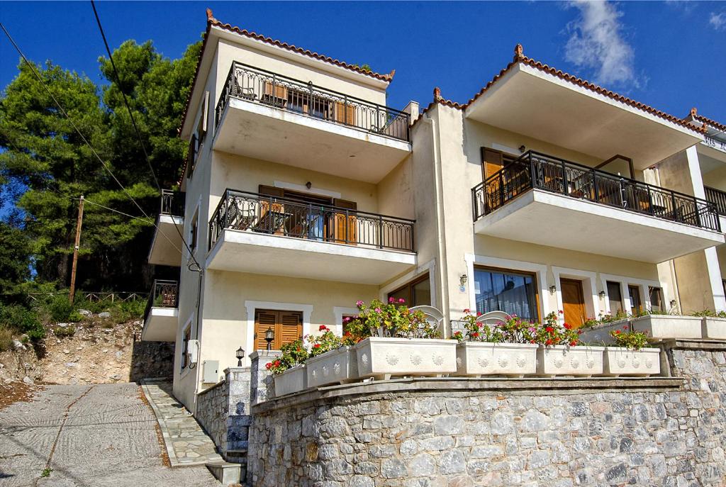 a white house with balconies on a stone wall at Eden Apartments in Neo Klima