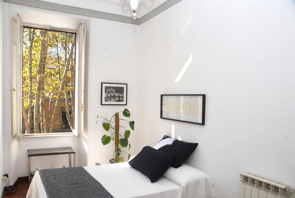 ローマにあるBianco E Nero Apartmentの白いベッドルーム(ベッド1台、窓付)